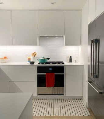 Minimal white fitted kitchen with integrated appliances